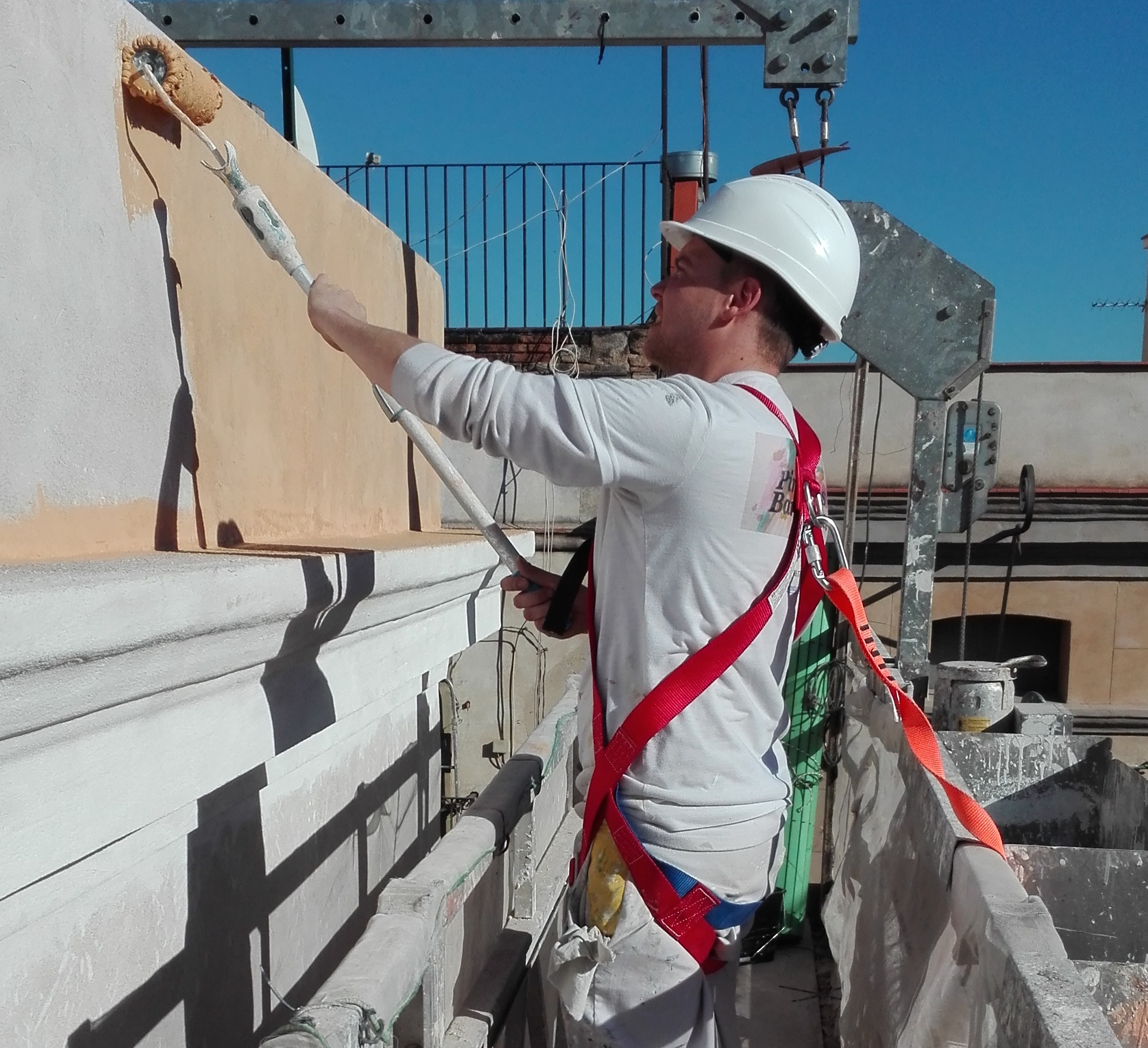 Pintor trabajando en la fachada de un edificio